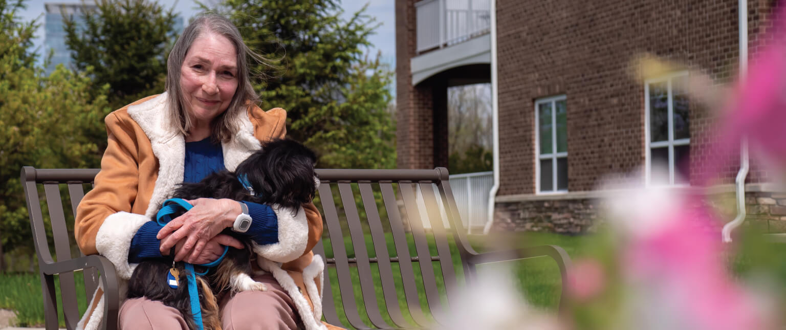 senior-woman-holding-dog (1) Senior woman holding her dog outside